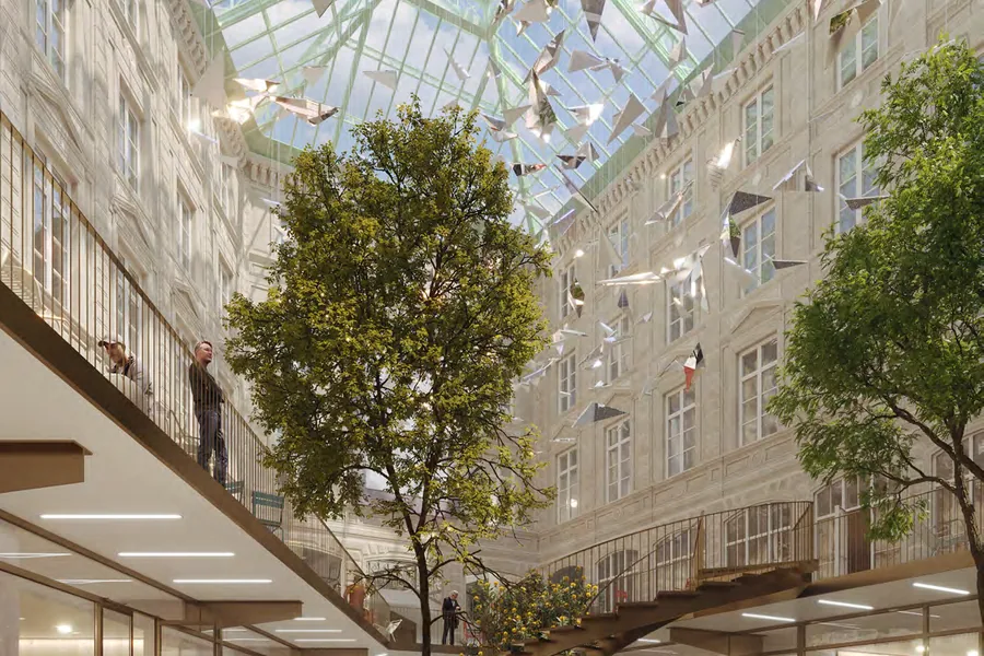 La cour intérieure de l’Étoile du Nord, couverte d’une verrière, avec un arbre planté en pleine terre.